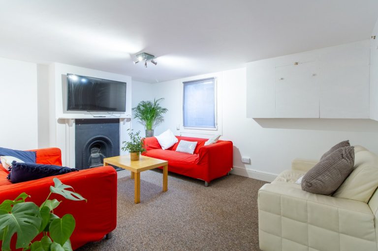 Living room at 5 St Pauls Street North, Cheltenham GL50 4AQ, featuring three sofas, a fireplace and a wall-mounted TV