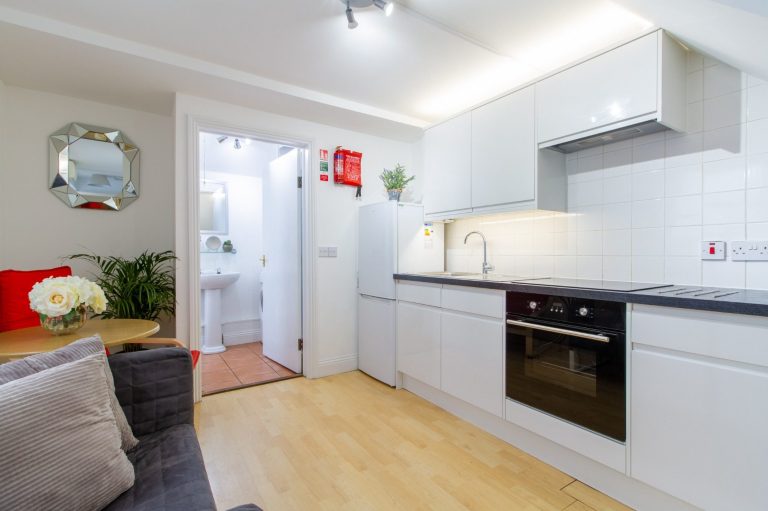 Contemporary kitchen at 5 St Pauls Lane, Cheltenham GL50 4AT, with white cabinets and sleek black countertops.